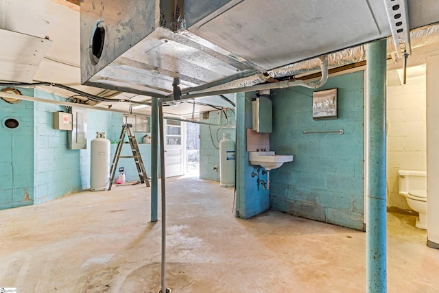 unfinished basement featuring water heater and a sink