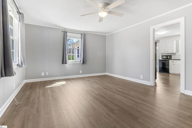 empty room with a ceiling fan, dark wood finished floors, baseboards, and ornamental molding