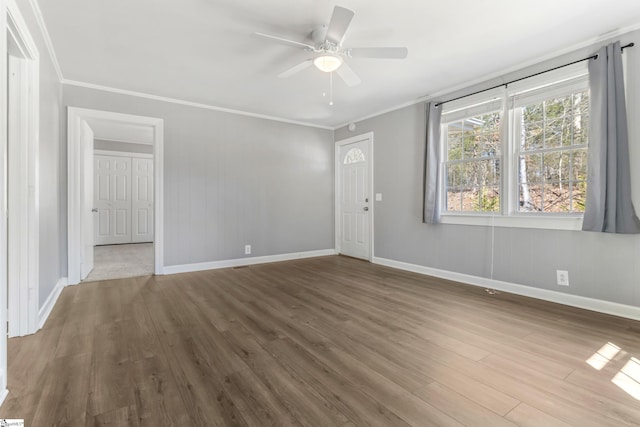 interior space featuring baseboards, ornamental molding, ceiling fan, and wood finished floors