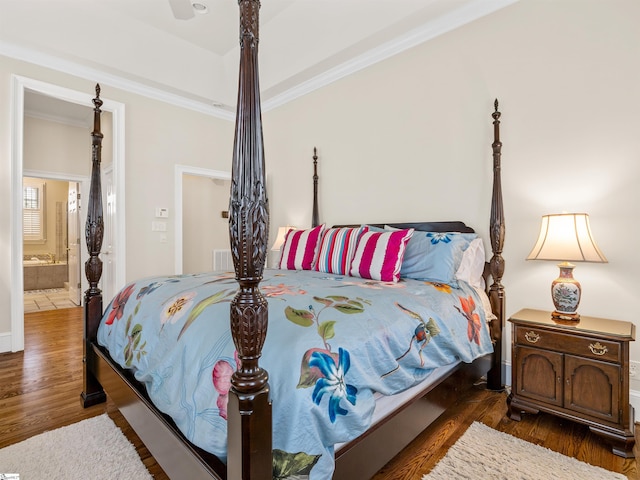 bedroom with ensuite bathroom, wood finished floors, visible vents, and crown molding