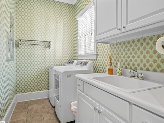 washroom with wallpapered walls, cabinet space, baseboards, separate washer and dryer, and a sink