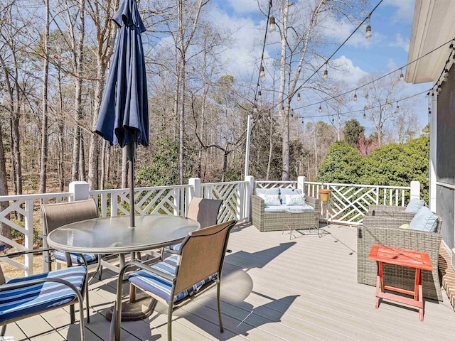 wooden terrace with outdoor dining area and an outdoor living space