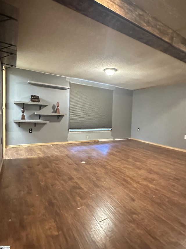 interior space with a textured ceiling, baseboards, and wood finished floors