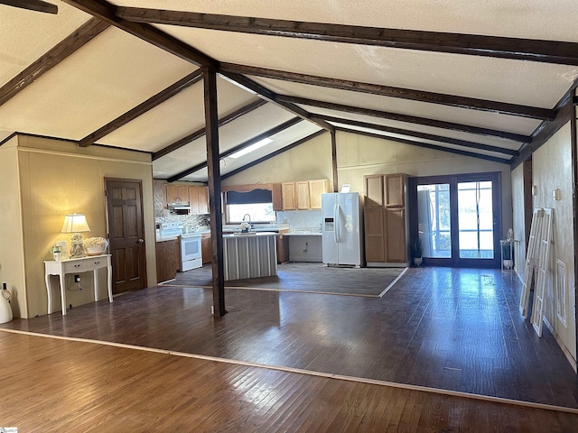 unfurnished living room with dark wood finished floors, lofted ceiling with beams, and a sink