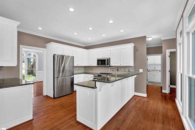 kitchen featuring stainless steel appliances, dark wood-style flooring, a peninsula, and white cabinets