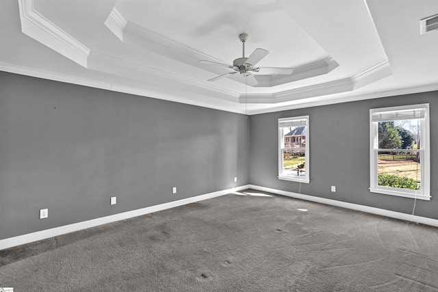 carpeted spare room with ceiling fan, a tray ceiling, baseboards, and ornamental molding