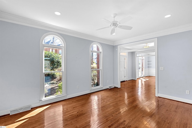 unfurnished room with visible vents, crown molding, baseboards, and wood finished floors