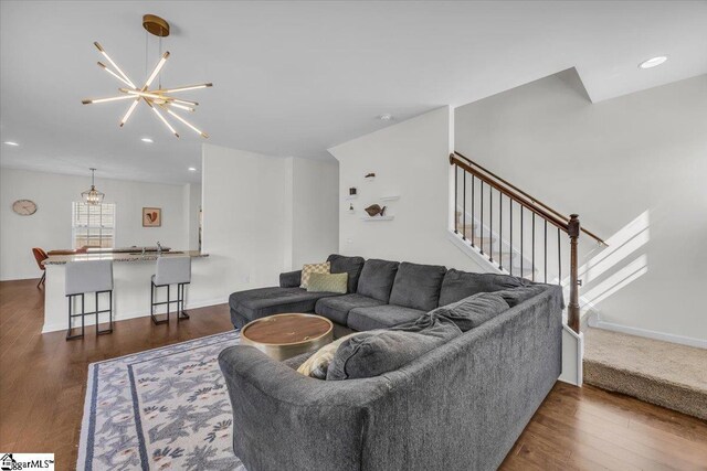 living room with baseboards, stairway, dark wood-type flooring, a notable chandelier, and recessed lighting