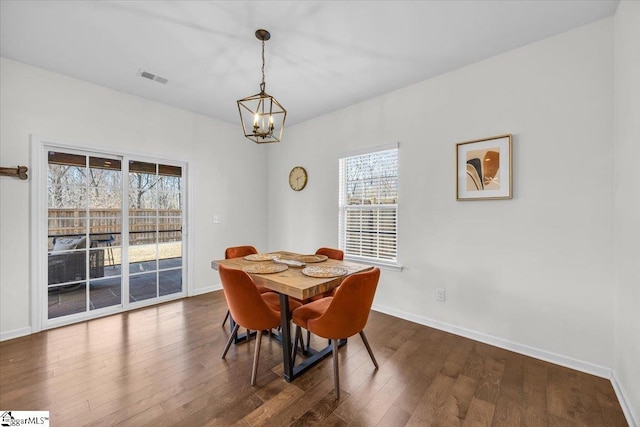 dining space with dark wood-style flooring, visible vents, and baseboards