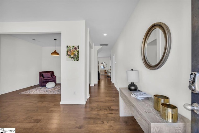 corridor with recessed lighting, visible vents, baseboards, and wood finished floors