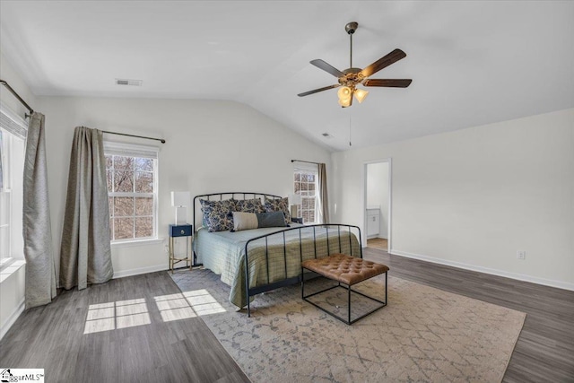 bedroom with vaulted ceiling, wood finished floors, visible vents, and baseboards