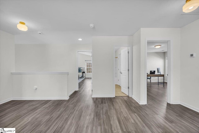 empty room with dark wood-type flooring and baseboards