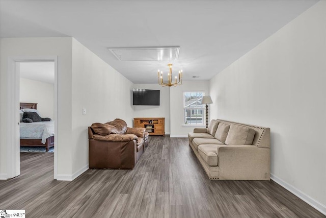 living area with a notable chandelier, baseboards, and wood finished floors