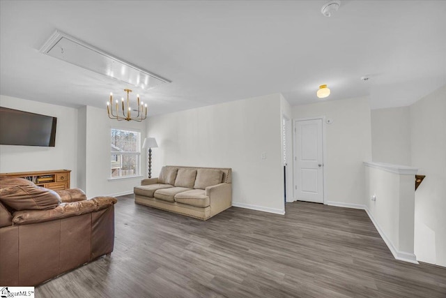 living area featuring attic access, baseboards, and wood finished floors