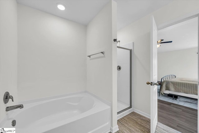 ensuite bathroom with a stall shower, ensuite bath, a garden tub, and wood finished floors