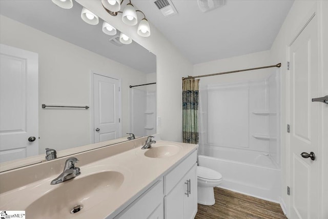 bathroom featuring visible vents, wood finished floors, a sink, and shower / bath combo with shower curtain