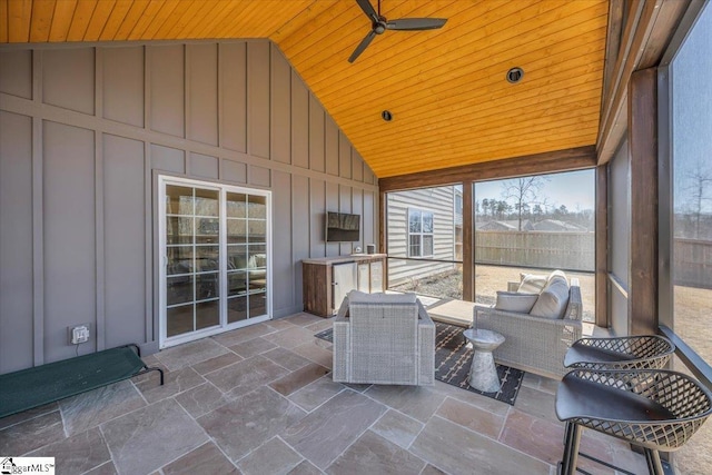 unfurnished sunroom featuring a ceiling fan, wooden ceiling, and vaulted ceiling