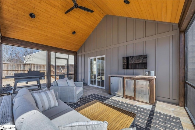 sunroom / solarium featuring vaulted ceiling, ceiling fan, and wood ceiling