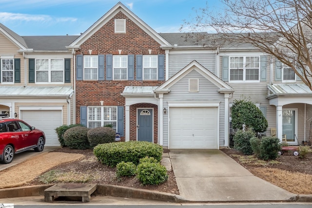 townhome / multi-family property featuring driveway, brick siding, and an attached garage