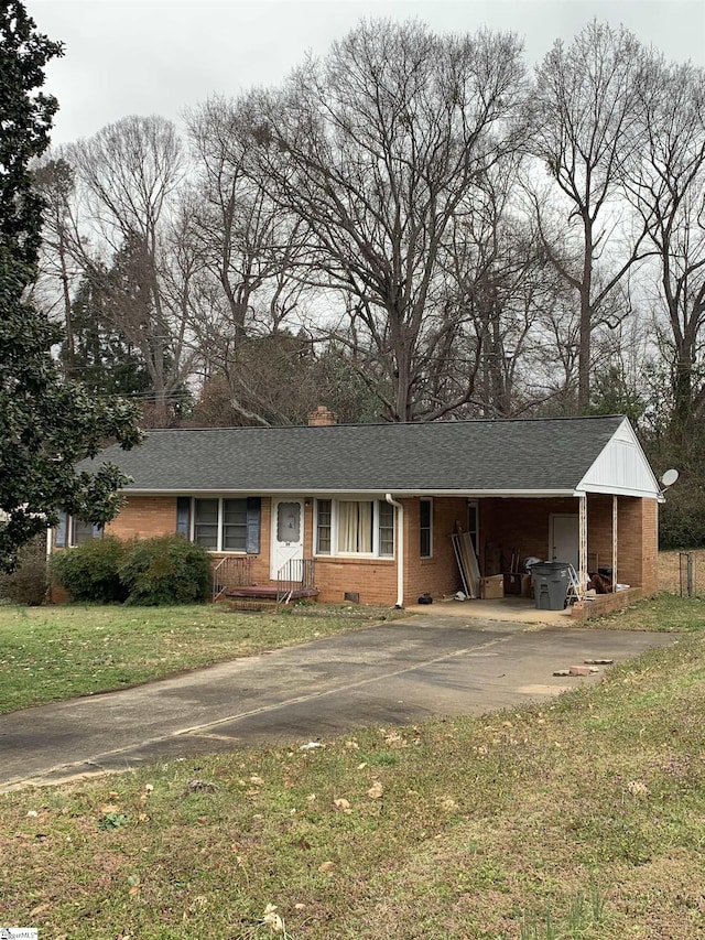 ranch-style home with driveway, brick siding, roof with shingles, crawl space, and a front yard