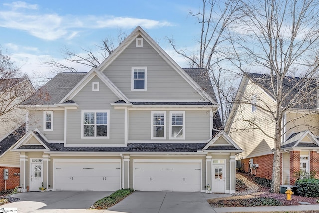 view of front of home with concrete driveway, a shingled roof, and an attached garage