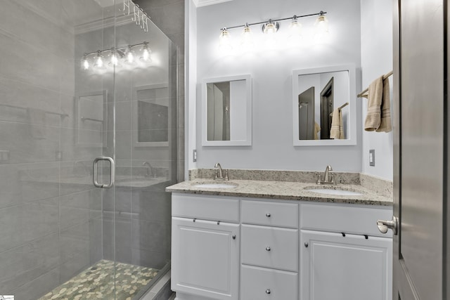 full bath with a stall shower, a sink, and double vanity