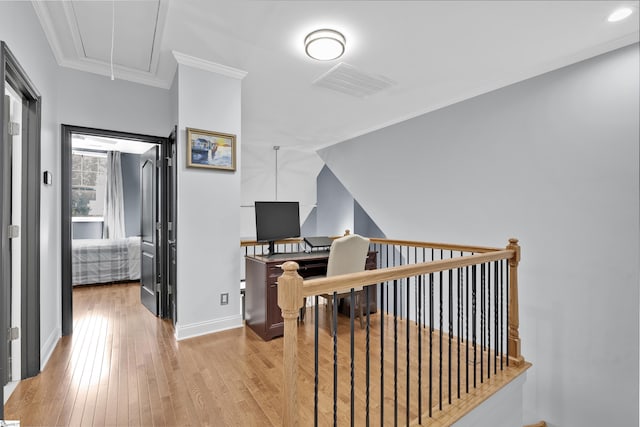 hallway featuring crown molding, visible vents, attic access, wood finished floors, and baseboards