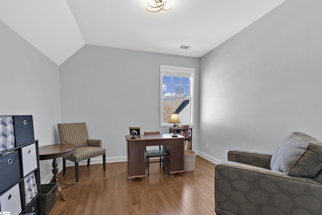 home office with vaulted ceiling, wood finished floors, visible vents, and baseboards