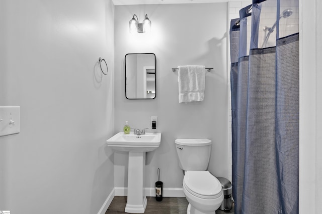 full bath featuring toilet, a sink, wood finished floors, baseboards, and a shower with curtain