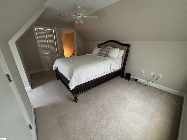 bedroom with lofted ceiling, a closet, a ceiling fan, carpet flooring, and baseboards