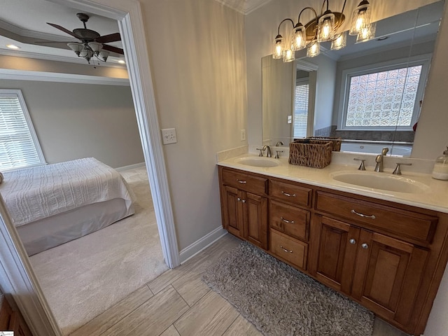 ensuite bathroom with double vanity, ornamental molding, a sink, and connected bathroom