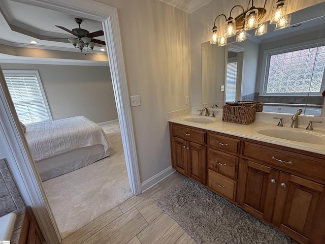 ensuite bathroom with ornamental molding, connected bathroom, a sink, and double vanity