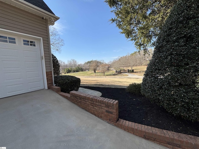 view of yard with a garage and driveway