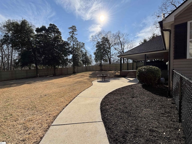 view of yard featuring a fenced backyard, a fire pit, and a patio