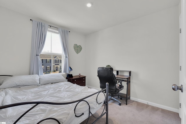 bedroom featuring light carpet and baseboards