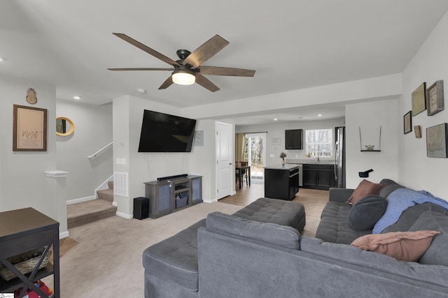 living area with a ceiling fan, recessed lighting, baseboards, and stairs