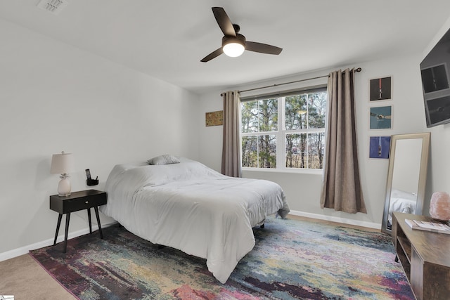 carpeted bedroom with baseboards, visible vents, and a ceiling fan