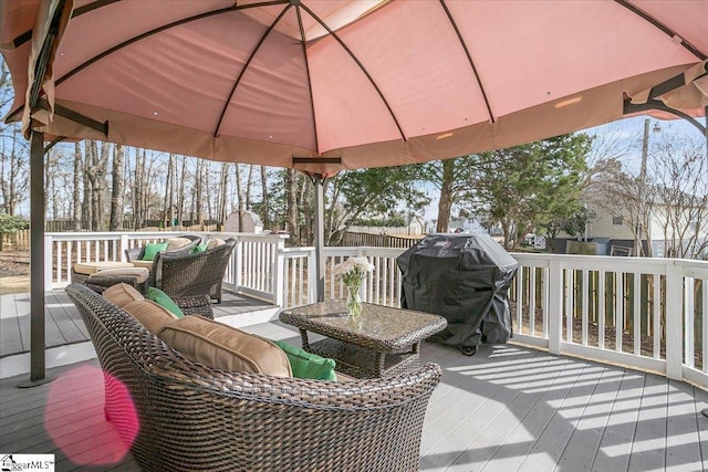 wooden deck featuring a grill, an outdoor living space, and fence