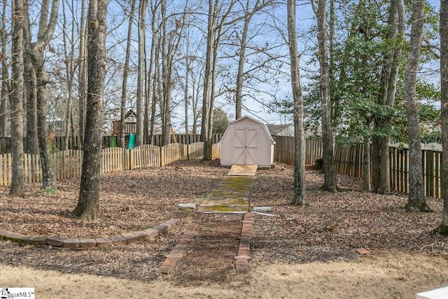 view of yard with a shed, a fenced backyard, and an outdoor structure