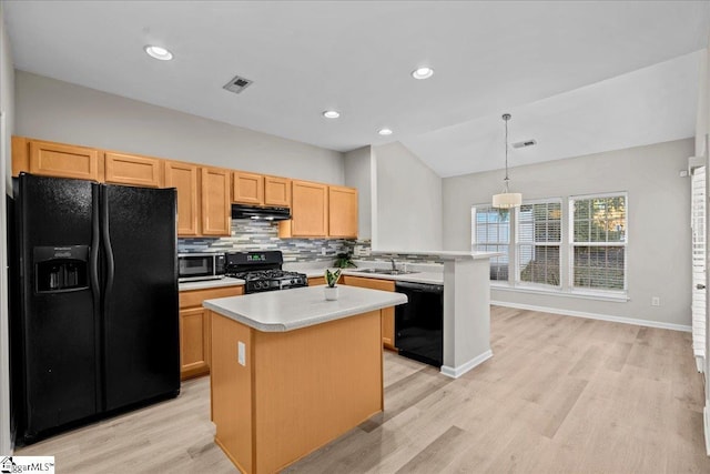 kitchen with a peninsula, a sink, visible vents, backsplash, and black appliances