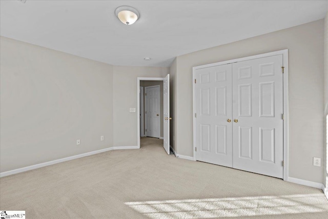 unfurnished bedroom featuring a closet, carpet flooring, and baseboards