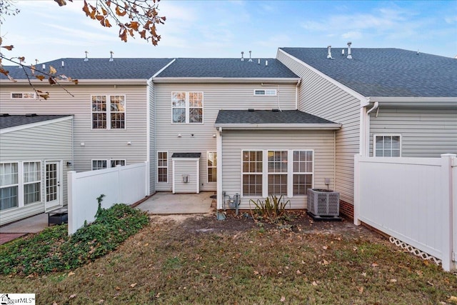 back of house featuring central AC unit, a patio area, fence, and a shingled roof