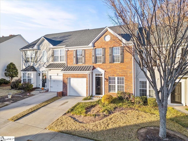 townhome / multi-family property featuring driveway, a garage, metal roof, a standing seam roof, and brick siding