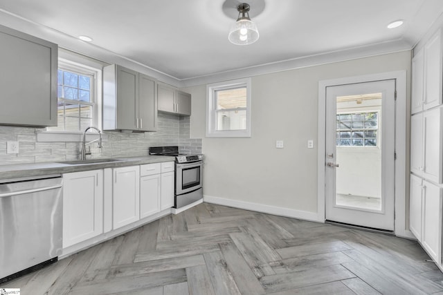 kitchen with plenty of natural light, tasteful backsplash, stainless steel appliances, and a sink