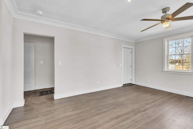 unfurnished room featuring baseboards, ornamental molding, ceiling fan, and wood finished floors