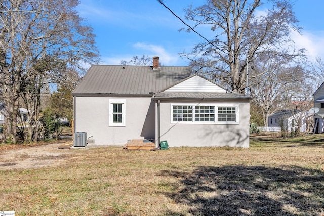 back of property featuring metal roof, a yard, cooling unit, and stucco siding