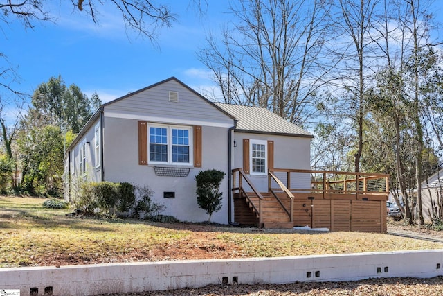 view of front of property featuring stucco siding, crawl space, metal roof, a wooden deck, and stairs