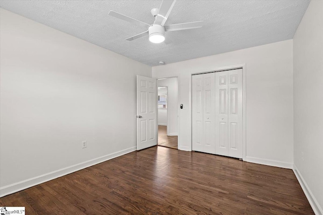 unfurnished bedroom with a closet, a textured ceiling, baseboards, and wood finished floors