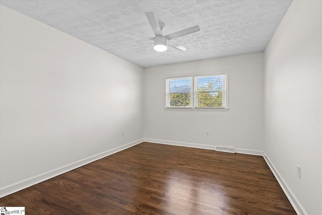 spare room with a ceiling fan, wood finished floors, visible vents, and baseboards