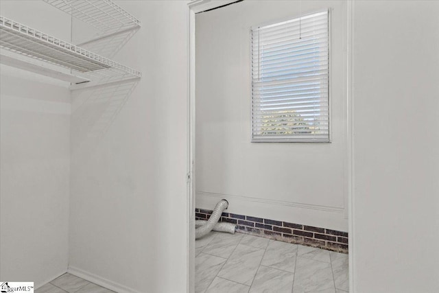 walk in closet with marble finish floor